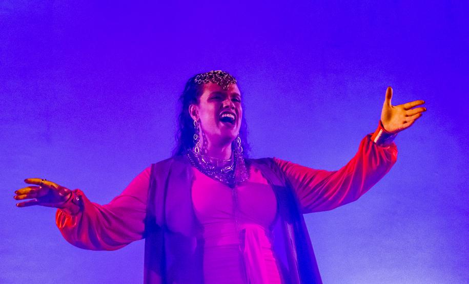 Elenco da ópera em cena com iluminação colorida