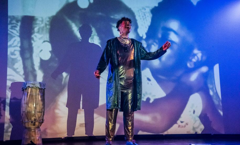 Elenco da ópera em cena com iluminação colorida