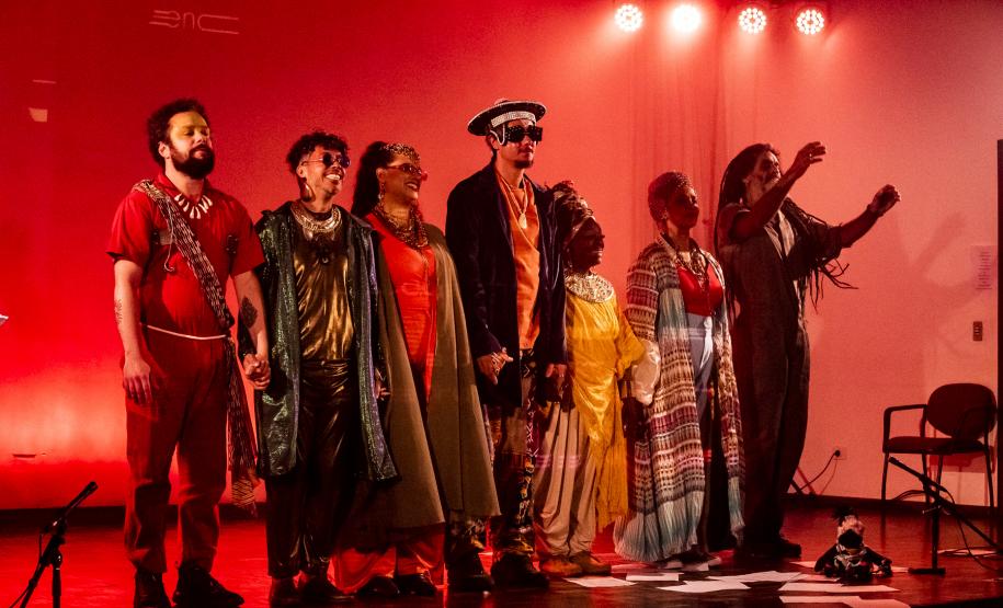 Elenco da ópera em cena com iluminação colorida