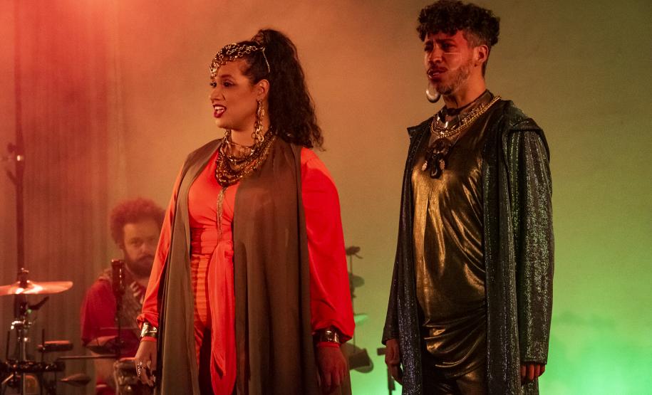 Elenco da ópera em cena com iluminação colorida