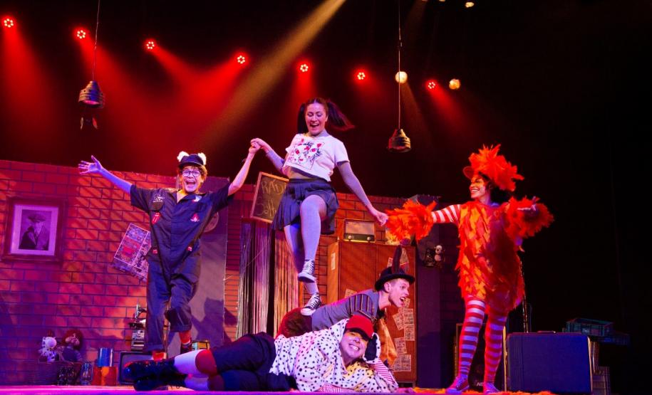 Atores em cena com iluminação vermelha