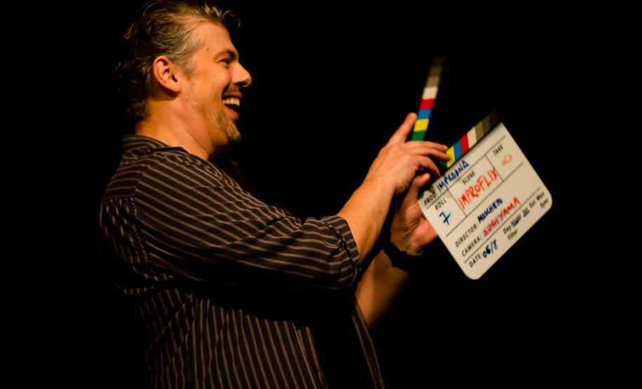 Diretor em cena com claquete na mão