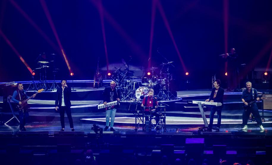 banda no palco com jogo de luzes em azul e vermelho