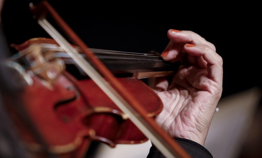 foto destaca mão feminina tocando violino