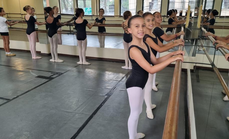 bailarinos em ensaio, posicionadas em frente à barra e espelho