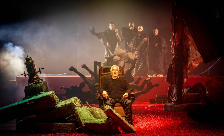 Marco Nanini atua em peça. Luzes vermelhas e verdes se dissipam com fumaça no palco