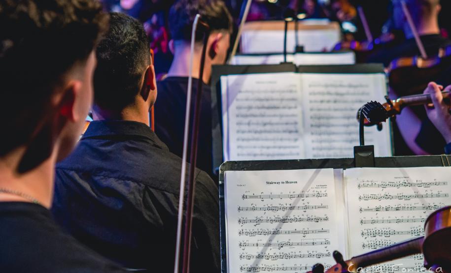 músicos enfileirados com partituras à frente