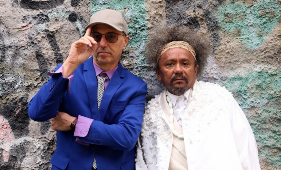 Chico César e Zeca Baleiro em imagem de divulgação do novo álbum "Ao Arrepio da Lei". Os artistas posam para foto em frente a uma parede com pinturas urbanas