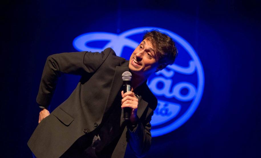 Cadu Scheffer com microfone em palco