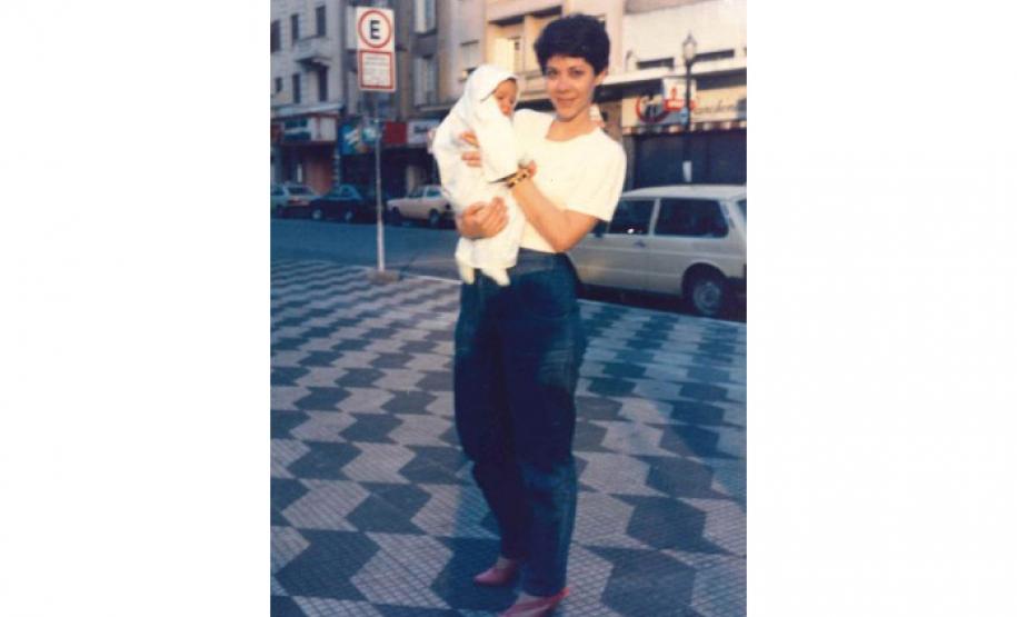 Analaura na calçada segurando Carla Maria no colo