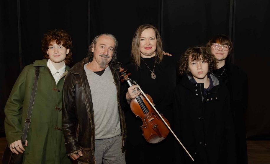 Romildo, Juliane e filhos. Juliane segura o violino na mão enquanto todos posam para foto