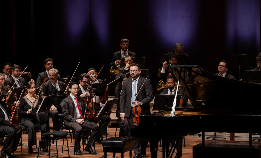 spalla da orquestra de pé em frente aos demais músicos