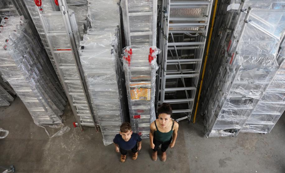 sala repleta de escadas de serviço. visão de cima, atores estão olhando para a câmera ao alto