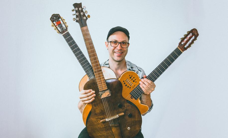 Músico Rodrigo Simões, com 3 instrumentos de corda