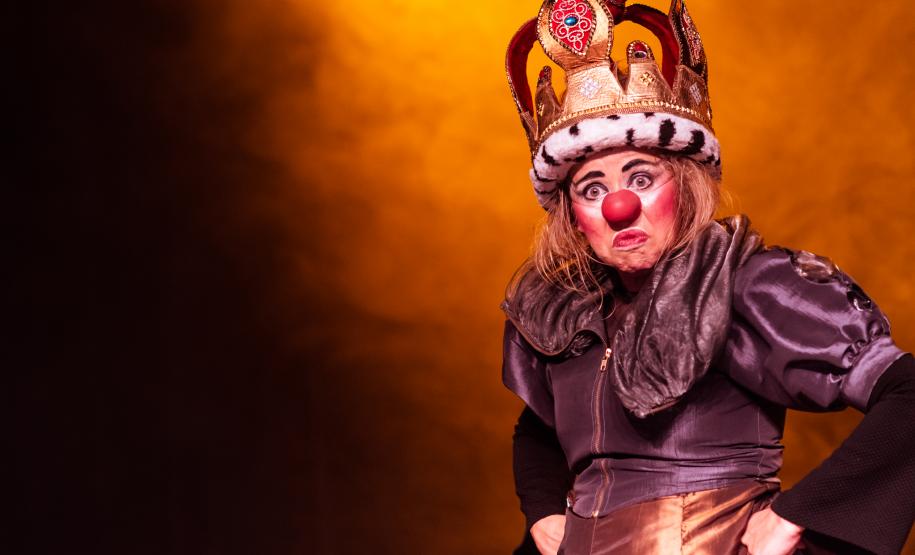 palhaça com vestes de rei e feição irritada