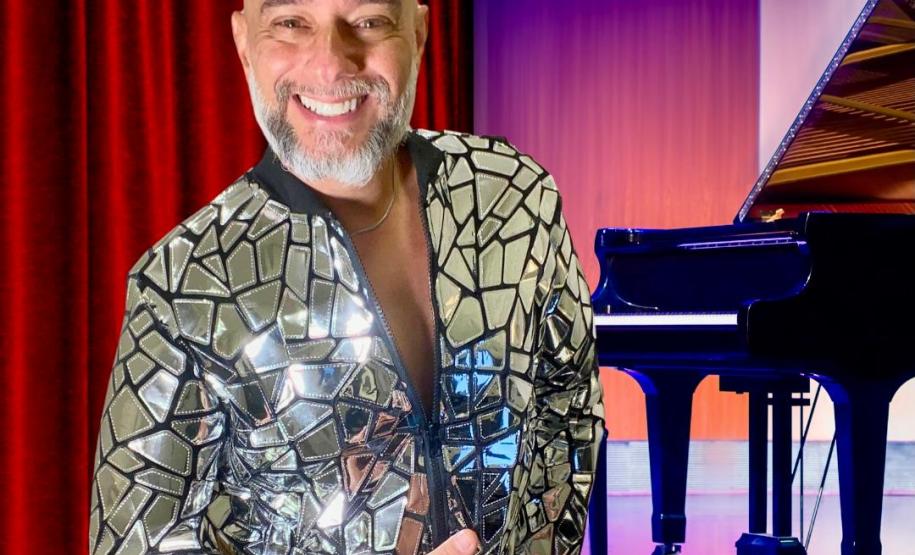 Pianista em primeiro plano com jaqueta brilhante; piano ao fundo do palco.