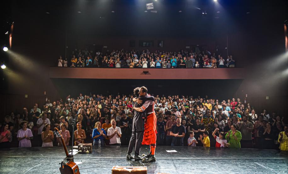 palhaços se abraçam no palco do Guairinha